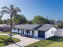 Aerial view of a newly renovated single-story home with a pristine lawn, modern roof, and an attached garage at 352 79Th Ne Ave, St Petersburg, FL 33702