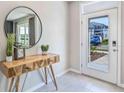 Bright entryway with tile floors, accent table, and a mirror with a view of the exterior at 35670 Lockman Way, Zephyrhills, FL 33541
