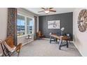 Stylish office space featuring a decorative accent wall, ceiling fan, and large picture window at 35727 Lockman Way, Zephyrhills, FL 33541
