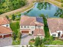 Aerial view of home with a backyard pond, solar panels, and tile roof at 4024 Woods Rider Loop, Odessa, FL 33556