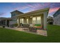 Relaxing covered patio with outdoor seating, string lights, and a fan at 597 Ozona Village Dr, Palm Harbor, FL 34683