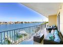 A cozy balcony setup features comfortable seating and offers stunning views of the water and nearby docks at 600 Bayway Blvd # 304, Clearwater, FL 33767