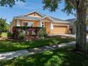 Well-maintained home with an attached two car garage, a lush lawn, and meticulously trimmed shrubbery at 6018 Gannetdale Dr, Lithia, FL 33547