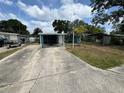 Wide angle view of a single story home, long drive and carport at 6047 67Th N Ave, Pinellas Park, FL 33781
