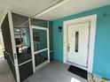 The front door is white with glass inlay, a screened in porch and turquoise wall are also visible at 6047 67Th N Ave, Pinellas Park, FL 33781
