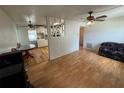 Open living room and dining area featuring sleek wood laminate floors, natural light, and modern ceiling fans at 6047 67Th N Ave, Pinellas Park, FL 33781