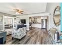 Open-concept living room with hardwood floors, modern furniture, and an archway leading into the kitchen at 6207 Gulfport S Blvd, Gulfport, FL 33707
