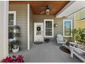 Inviting front porch with wood ceiling, comfortable seating, and decorative plants at 6922 Duffy Ln, Tampa, FL 33616