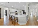 Bright kitchen featuring a large quartz countertop island, white cabinets, and modern appliances with hardwood flooring at 7207 Peregrina Loop, Wesley Chapel, FL 33545