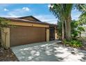 Attached two-car garage with mature landscaping and direct access to the home's screened entry at 740 Crystal Dr, Palm Harbor, FL 34683