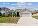 Charming single-story home featuring a two-car garage and well-manicured lawn at 8105 Bilston Village Ln, Gibsonton, FL 33534