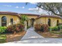 Stucco home with a red tile roof, manicured landscaping, and an arched front entrance at 9611 125Th N St, Seminole, FL 33772