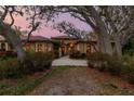 Charming home with a red tile roof, lush landscaping, and mature trees at 9611 125Th N St, Seminole, FL 33772
