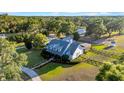 Expansive property featuring a well-maintained lawn, mature trees, and a charming two-story home with metal roof at 10101 Bryant Rd, Lithia, FL 33547