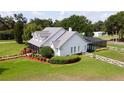 Charming white house with lush landscaping, a metal roof, and a screened-in pool, creating a serene backyard oasis at 10101 Bryant Rd, Lithia, FL 33547