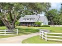 Charming exterior view of home featuring a metal roof, covered porch, and lush green lawn with mature trees at 10101 Bryant Rd, Lithia, FL 33547