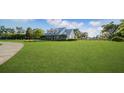 Expansive front lawn surrounds a charming home with lush landscaping, a fence and mature trees at 10101 Bryant Rd, Lithia, FL 33547