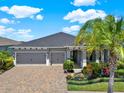Beautiful one-story home with a three-car garage, brick driveway, and well-maintained landscaping at 11743 Lake Lucaya Dr, Riverview, FL 33579