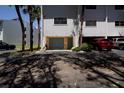 Exterior shot of unit showing private garage and guest parking with mature palm trees at 12140 Capri S Cir, Treasure Island, FL 33706
