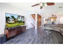 Open-concept living room features wood-look floors, modern lighting, and staircase at 12140 Capri S Cir, Treasure Island, FL 33706