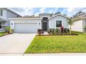 Well-manicured front yard featuring lush green grass and colorful landscaping around the home at 13061 Brookside Moss Dr, Riverview, FL 33579