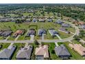 A stunning aerial view of the property nestled in a lush, green neighborhood with a nearby golf course at 13805 Carryback Dr, Dade City, FL 33525