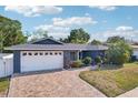 Beautiful one-story home with a well-maintained front yard, mature trees, and an inviting brick driveway at 206 Timberview Dr, Safety Harbor, FL 34695