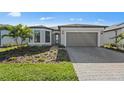 Charming home featuring a brick driveway, two-car garage, and beautifully landscaped front yard at 2528 Charter Oak Dr, North Port, FL 34289