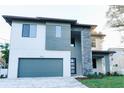 Modern two-story home with a gray color scheme, a two-car garage, and a well-manicured front yard at 3310 W Rogers Ave, Tampa, FL 33611