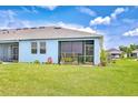 Well-maintained backyard with screened-in porch and a lush green lawn, perfect for outdoor living at 3765 Maxwell Park Dr, Sun City Center, FL 33573