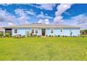 Inviting single-story home featuring a well-kept lawn and colorful flower beds accentuating the façade at 3765 Maxwell Park Dr, Sun City Center, FL 33573