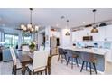 Bright, modern kitchen featuring a large island with seating and stainless steel appliances at 3765 Maxwell Park Dr, Sun City Center, FL 33573