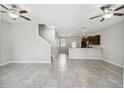 Bright and airy living room featuring tile flooring and ceiling fans throughout the open concept first floor at 4183 Ballantrae Blvd, Land O Lakes, FL 34638