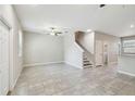 Spacious living area showcasing staircase, tile flooring, and modern fixtures with a neutral color palette at 4183 Ballantrae Blvd, Land O Lakes, FL 34638