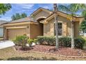 Beautiful single Gathering home featuring a two-car garage, neat landscaping and tan-colored exterior at 4500 Fieldview Cir, Wesley Chapel, FL 33545