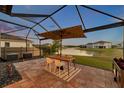 Screened-in lanai with patio furniture overlooking a tranquil water view, perfect for outdoor relaxation and entertaining at 4719 Tramanto Ln, Wesley Chapel, FL 33543