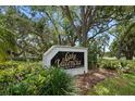Entrance sign for Lake Valencia West, framed by lush greenery and trees, inviting a serene community feel at 4765 Lake Valencia W Blvd, Palm Harbor, FL 34684