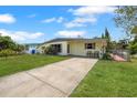 Inviting front of a one-story home with lush green lawn and long concrete driveway at 4932 Murray Hill Dr, Tampa, FL 33615