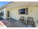 Charming front porch seating area with a small table outside the front door of the home at 4932 Murray Hill Dr, Tampa, FL 33615