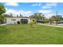View of the front yard of a house with a well-maintained lawn and mature trees at 4932 Murray Hill Dr, Tampa, FL 33615