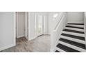 Bright entryway with a staircase, wood-look tile flooring, white trim, and a glass front door at 5917 Cat Claw Ln, Bradenton, FL 34210