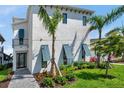 Charming two-story home with a manicured lawn, tropical landscaping, and colorful window shutters at 5917 Cat Claw Ln, Bradenton, FL 34210