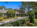 Gorgeous home with lush landscaping, a brick driveway, and a welcoming front entrance at 6352 W Maclaurin Dr, Tampa, FL 33647