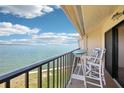 Balcony with a table and chairs overlooking beautiful water views on a sunny day at 7540 Sunshine Skyway S Ln # 217, St Petersburg, FL 33711
