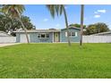 Charming blue single-story home with a green lawn and inviting yellow door at 7690 91St St, Seminole, FL 33777