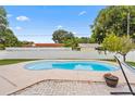 Backyard pool with a brick patio, white fence, and a relaxing hammock at 7690 91St St, Seminole, FL 33777