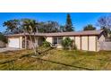 Charming one-story home with tropical landscaping and beige siding at 920 Palm Dr, Belleair Beach, FL 33786