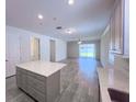 Open concept living and kitchen area with luxury vinyl floors and ample lighting at 10729 Planer Picket Dr, Riverview, FL 33569