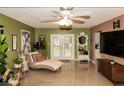 Bright living room with French doors, unique flooring, and chaise lounge, creating a welcoming space at 12213 Floral Ln, Thonotosassa, FL 33592