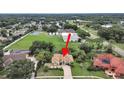Aerial view showcasing the home's location near a school and tennis courts at 1312 Fishing Lake Dr, Odessa, FL 33556
